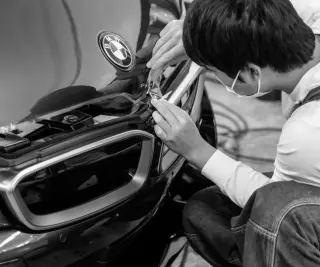 Hands installing film in the shop bay
