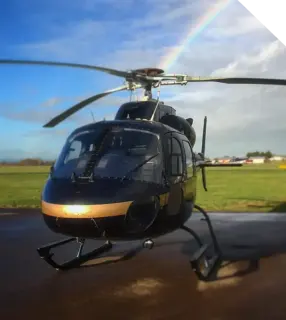 Twin Squirrel helicopter on the apron under a rainbow
