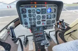 Instrument panel and flight controls inside a twin-engine helicopter cockpit