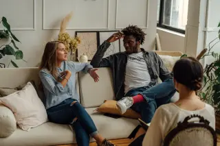 mixed race couple on couch with counselor