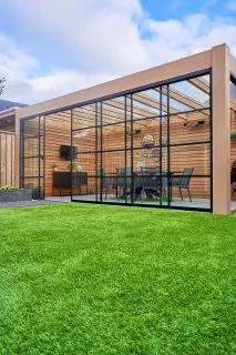 A glass enclosed patio with a table and chairs.