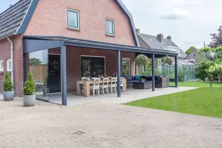 A patio with a table and chairs next to a house.