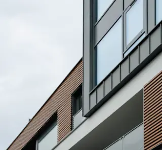 A sleek, modern architectural facade with clean lines and natural earth tones.
