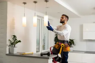 Electrician installs lamp lighting and spot loft style