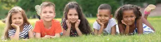 5 children laying in grass