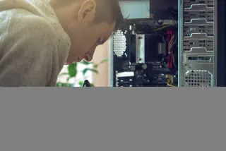 Man repairman is trying to fix using the tools on the computer