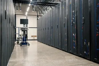 Allée d’une salle de serveurs avec des baies informatiques éclairées