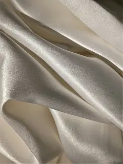 Tissu en satin beige lumineux avec citation inspirante sur les événements, ambiance chic et intemporelle pour organisation de mariages et réceptions privées - Malia Agency.