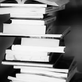 A tall stack of books in black and white.