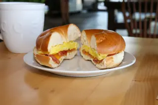 Bagel breakfast sandwich and a coffee mug.