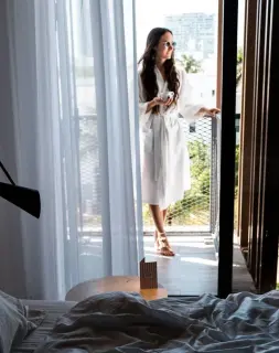 Woman in white robe on balcony overlooking Miami Beach at Upsun Hotel