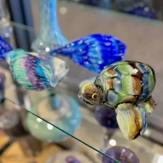 Close-up of colorful glass art pieces with swirled patterns in various shades of blue, green, purple, and brown.