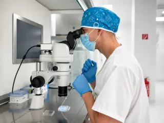 Vedec pracuje s mikroskopom.