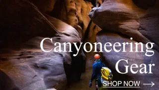 A man in full canyoneering gear stands in Pinecreek Canyon