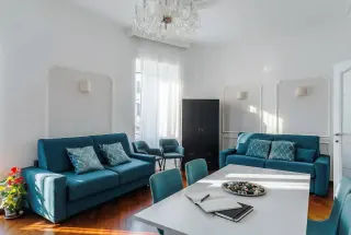 Soggiorno del Saint John Loft Roma con divani teal e lampadario di cristallo