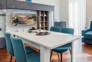 Area pranzo del Saint John Loft con sedie teal e Smart TV